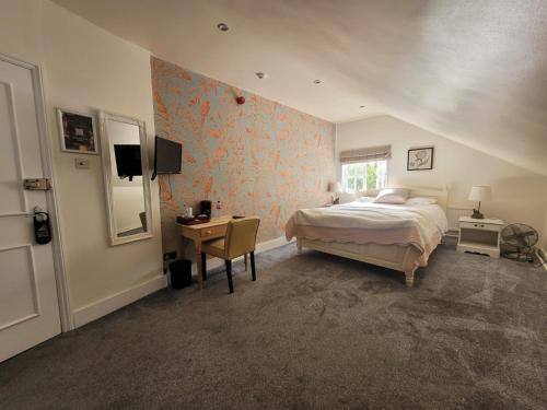 AshwellThree Tuns Ashwell的一间卧室配有一张床、一张书桌和一个窗户。