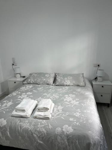 米哈斯Ataraxia Casa Vacacional的一间卧室配有一张床,上面有两条毛巾