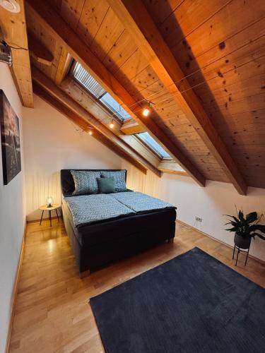 松托芬Ferienwohnung Alpenglühen的一间带一张床的卧室,位于带木制天花板的房间内