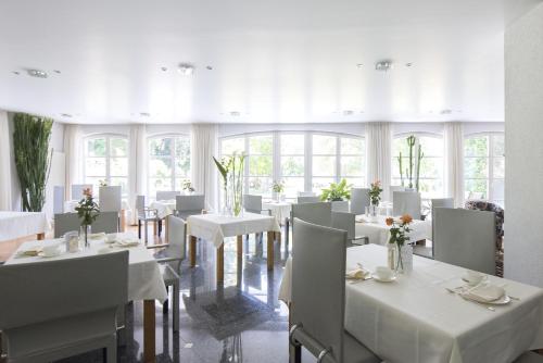 博登斯边的拉多夫采尔ArtVilla am See - buchbar April-Mai 2024的用餐室配有白色的桌子和白色的椅子