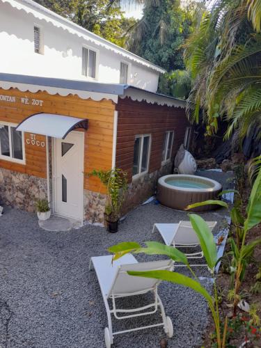 三河市VillaBadlou "Lodge Ti-Kaco Vanille"的后院设有两把椅子和游泳池