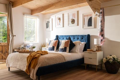 布兰德福德福鲁姆Copperbeech - Luxury Holiday with Private Hottub的一间卧室配有蓝色的床和枕头