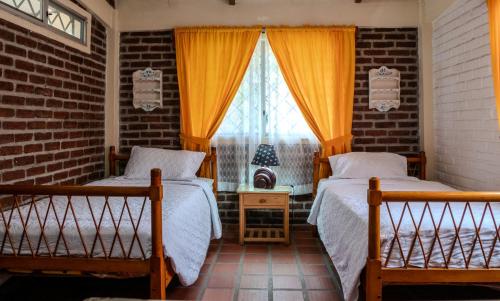 普拉亚斯Las villas de Yoly的带窗户的客房内的两张床