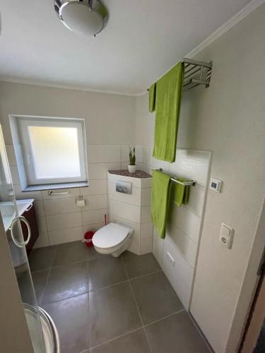 DittenheimHaus am gelben Berg的浴室设有卫生间、窗户和绿毛巾。