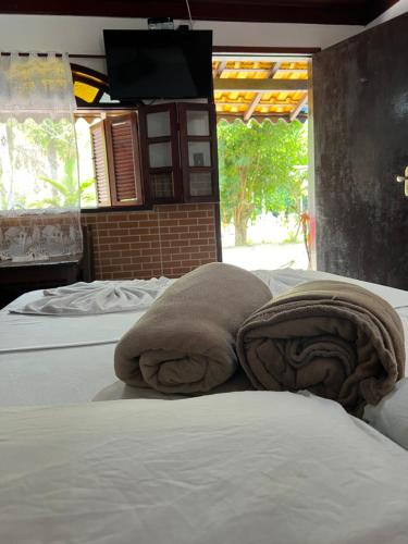 PinheiralPesque pague pousada do Carlinho的一间卧室配有两张带毛巾的床