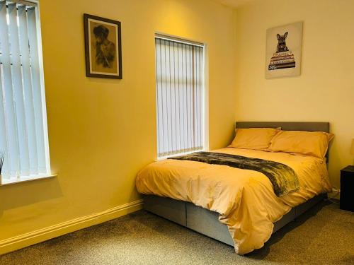 特伦特河畔斯托克Luxury Double & Single Rooms with En-suite Private bathroom in City Centre Stoke on Trent的一间卧室设有一张黄色墙壁和窗户的床