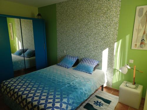 尼姆Chambre Cosy的一间卧室配有蓝色的床和镜子