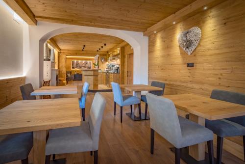 萨帕达Albergo Cavallino的餐厅拥有木墙和木桌及椅子