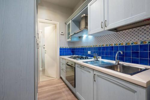 热那亚Cuore blu的厨房配有水槽和蓝色的瓷砖墙壁