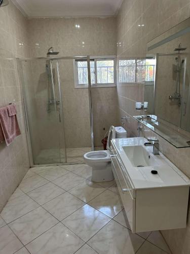 班珠尔Luxury 2 bedroom flat KerrSerign的带淋浴、卫生间和盥洗盆的浴室
