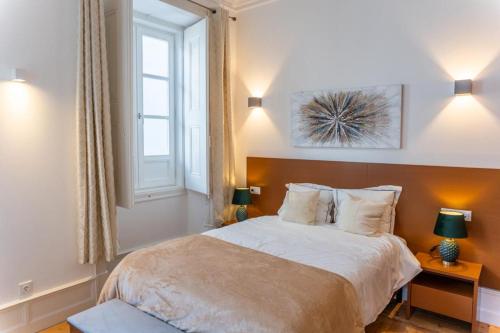 埃武拉Guest House - Palácio Diana的一间卧室配有一张床、两盏灯和一个窗户。