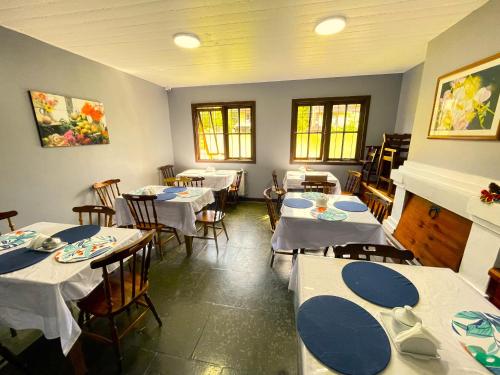 卡内拉Pousada Bella Serra的用餐室配有桌椅和白色的桌布