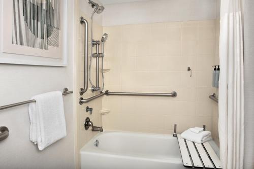 杰克逊维尔万怡酒店杰克逊弗拉格勒中心的浴室配有白色浴缸和淋浴。