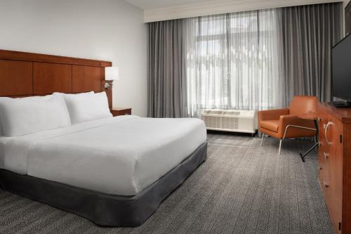 杰克逊维尔万怡酒店杰克逊弗拉格勒中心的酒店客房配有一张床、一张书桌和一台电视。