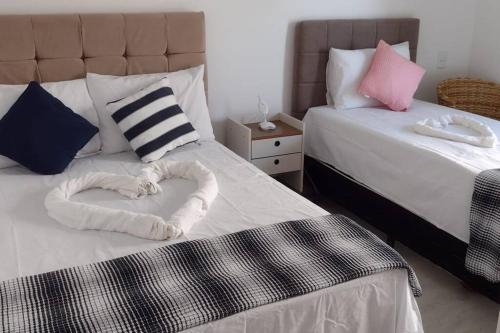 阿拉亚尔-杜卡布Beira Mar Residencial的一间卧室配有两张床,中间由毛巾制成