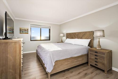 大洋城Oceanfront 2 Bedroom Modern Beach Condo w Pool的一间卧室配有一张大床和电视