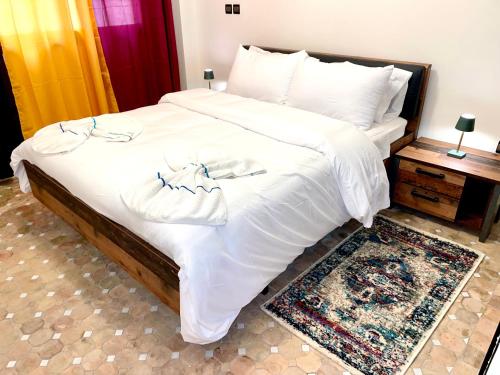 马拉喀什Perle en plein Gueliz的卧室配有一张带白色床单和毛巾的大床。