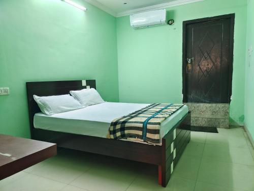 OngoleARUDRA BUDGET suites的一间设有床铺的卧室,位于一个拥有绿色墙壁的房间