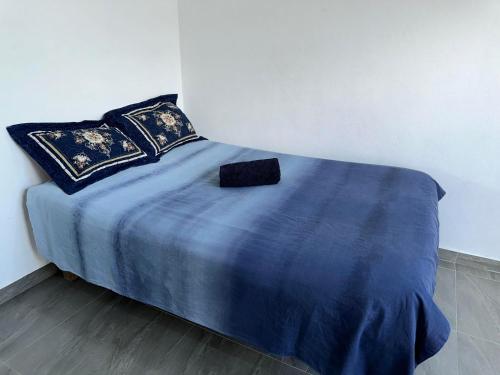 南迪Peace Hut的一张带蓝色毯子和枕头的床