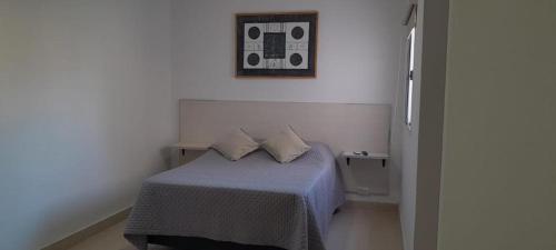 圣地亚哥-德尔埃斯特罗Monoambiente Céntrico2的一间卧室配有一张带两个枕头的床