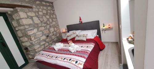 Santa Maria del MoliseIl Campanile的一间卧室配有一张红色的床和石墙