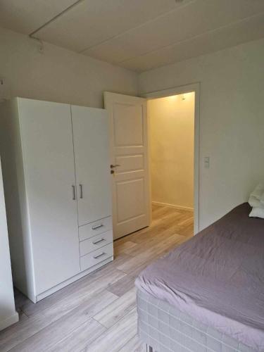 埃斯比约Enkeltværelse med fælles badeværelse的一间卧室配有一张床和一个衣柜及一扇门