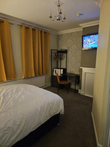 奥尔顿The Market Hotel的一间卧室配有一张床、一张书桌和一台电视