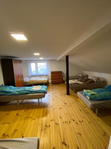 波兹南Apartamenty Glebowa 26的客房设有三张床,铺有木地板。