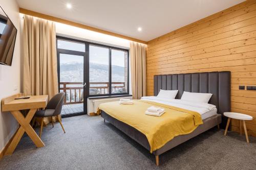布克维Yo Hotel的一间卧室配有一张床、一张书桌和一个窗户。