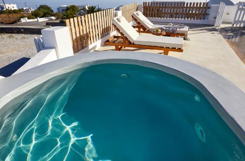 易莫洛林Athiri Santorini Hotel的一个带桌椅的小型游泳池