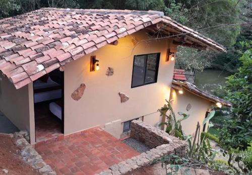 圣希尔Hotel Casas de Campo El Ciruelo的一间铺有瓷砖屋顶的小房子