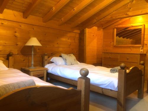 沙泰勒Chalet La piste du Linga的小木屋内一间卧室,配有两张床