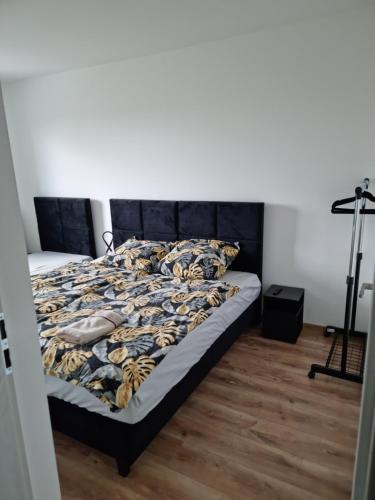 库特诺Perłowy Apartament的一间卧室配有一张带黑色床头板的床