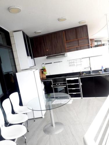 马瑙斯Tropical executive Ap 1411的厨房配有白色的椅子、桌子和橱柜。