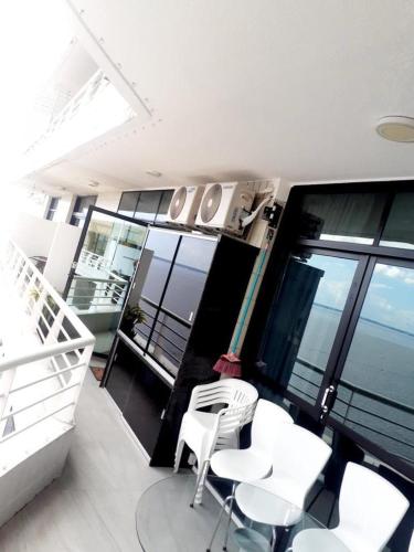 马瑙斯Tropical executive Ap 1411的阳台设有白色椅子和桌子的房间