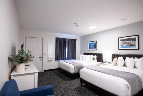 巴港Main Street Motel的酒店客房,设有两张床和一张蓝色椅子