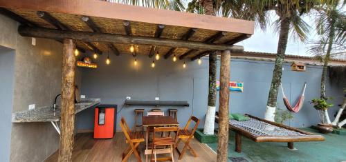 伊塔尼亚恩Hostel Praia Centro Itanhaém的木凉亭,带桌子和长凳