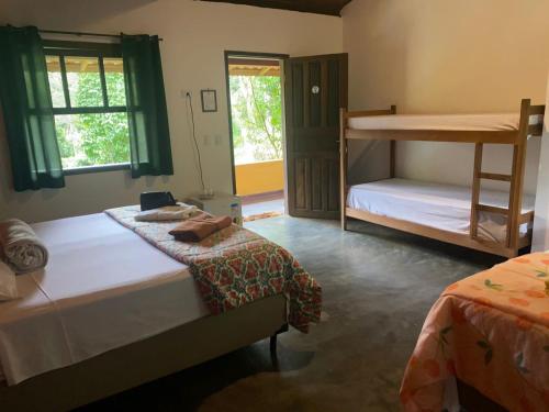 伊波兰加Pousada Rancho da Serra PETAR的一间卧室配有两张床和一张双层床。