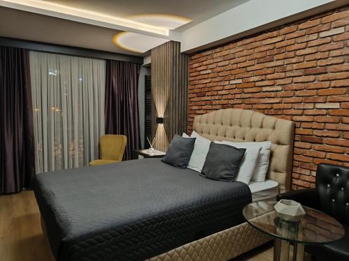 伊斯坦布尔Nomad Hub Istanbul Residence的一间卧室设有一张床和砖墙