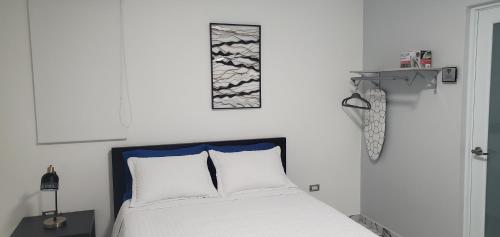 阿瓜迪亚2 PALMAS STR的一间卧室配有一张白色的床和蓝色床头板