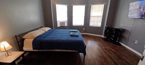 纽瓦克Willoughby的一间卧室配有一张带蓝色毯子的床和两个窗户。