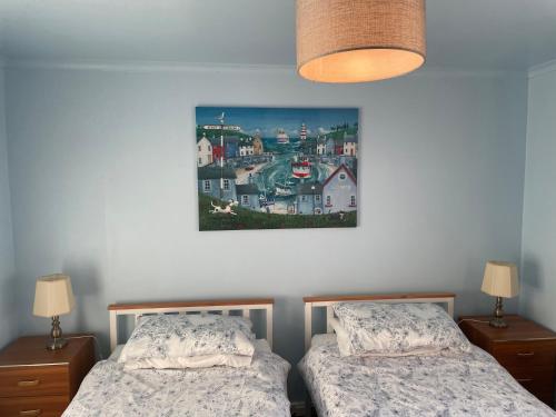 巴利米纳Laurel Country Cottage的一间卧室设有两张床,墙上挂着一幅画