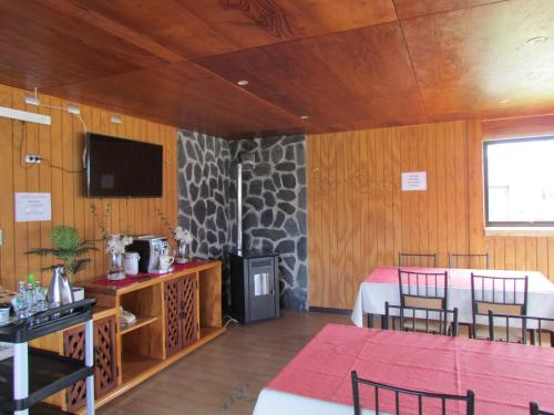 奥尔诺皮伦Hostería Antupirén的客房设有1张床、1张桌子和1台电视。
