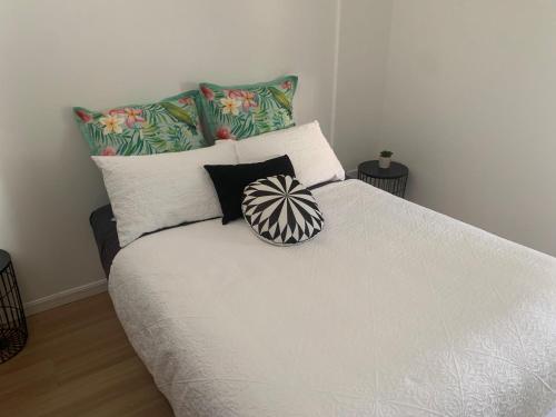 Yandina扬迪纳大篷车公园露营旅馆的卧室配有带枕头的白色床