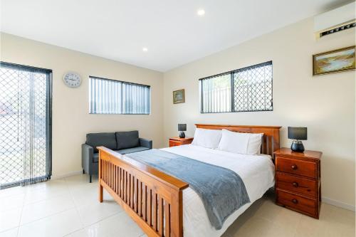 尼尔森湾14A Grafton St - Pet friendly studio with air con and wi-fi的一间卧室配有一张床和一把椅子