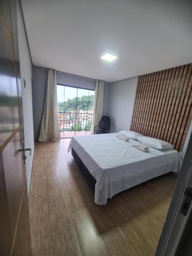 安格拉杜斯雷斯Casa Angra vista pro mar的一间卧室设有一张床和一个大窗户
