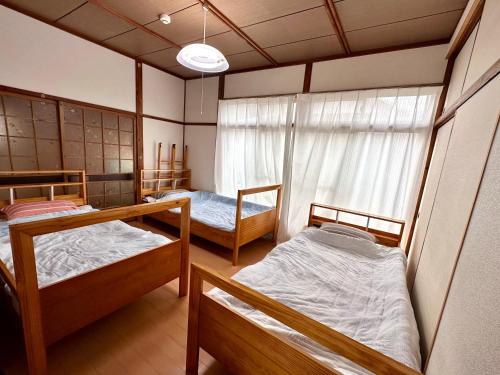 WakamatsuGuest House Island的客房设有三张双层床和一扇窗户。