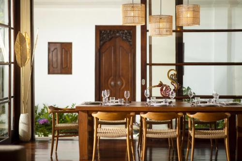 金巴兰Jimbaran Beach Villas by Nakula的一间带木桌和椅子的用餐室