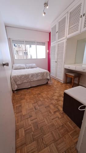 蒙得维的亚DepArt en Rambla Punta Carretas的一间卧室配有一张床,铺有木地板