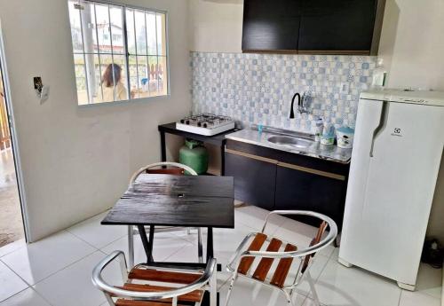PratigiCasa em Pratigi, Universo Paralelo, Ituberá Ba.的厨房配有桌子、两把椅子和冰箱